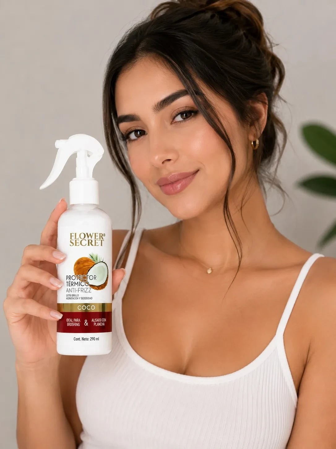 Mujer sosteniendo protector térmico Flower Secret de coco de ÉL&ELLA MAKEUP Y ACCESORIOS para un cabello sin frizz
